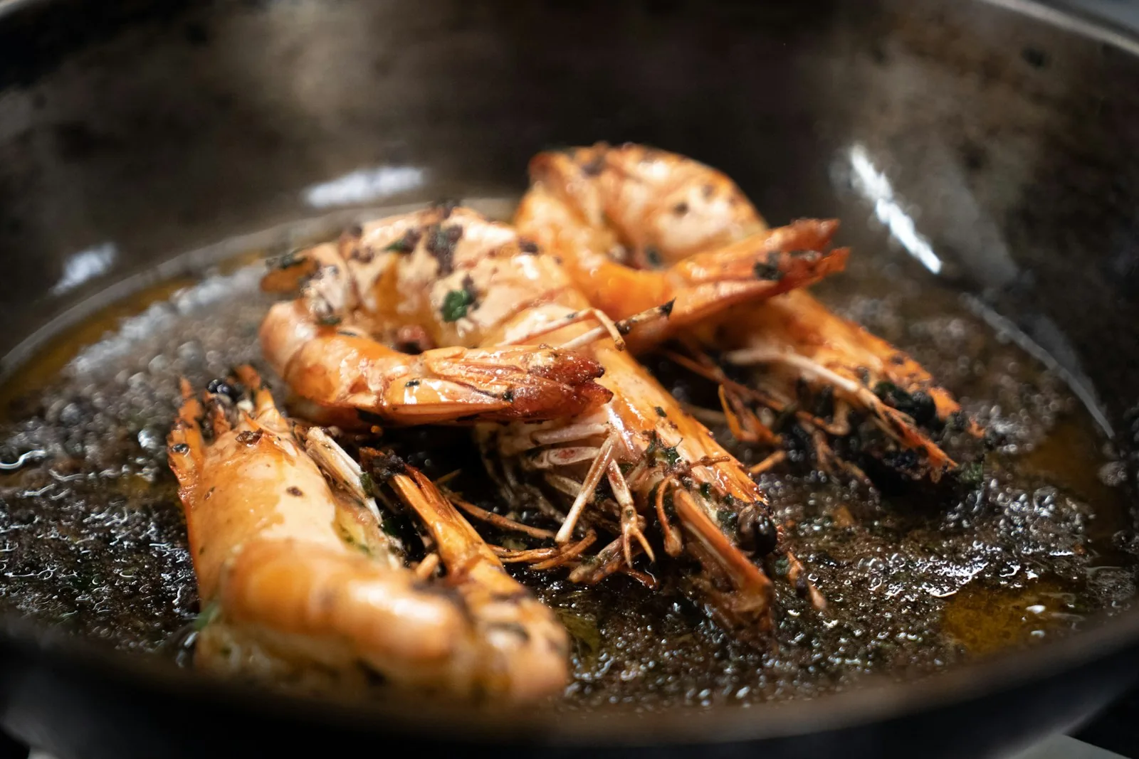 Škampi na buzaru, Adriatic scampi cooking in a pan with garlic and oil