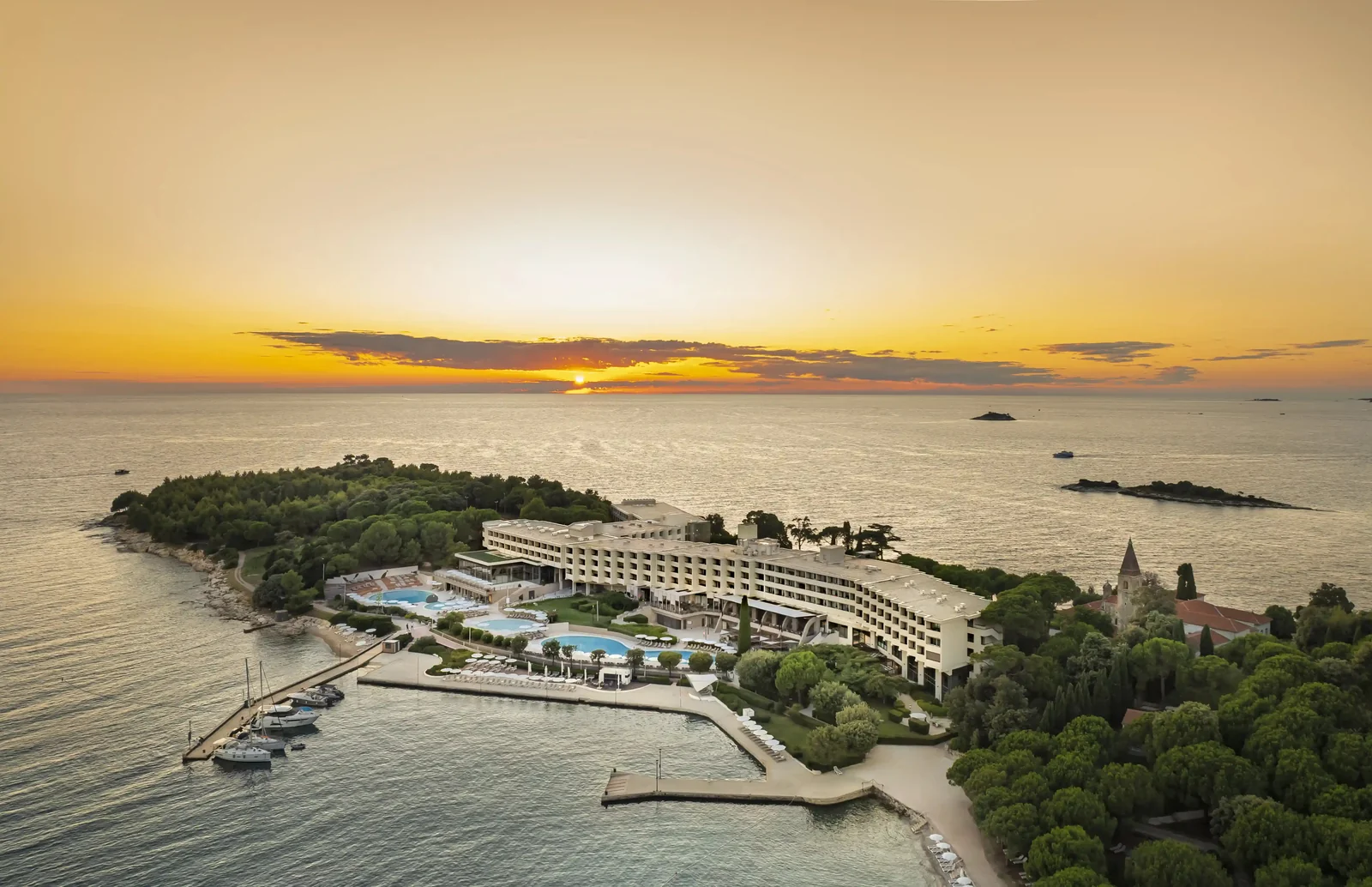 Aerial view of Island Hotel Istra with pools on Red Island at sunset