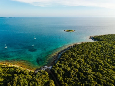 The islet off Palud in the evening light, boats in the bay.