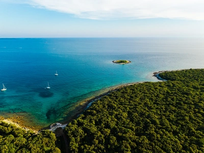 Open sea and a distant islet beyond the Palud shore.
