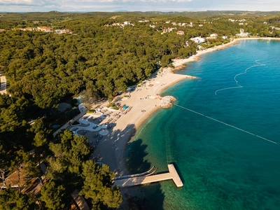 Mala šljunčana uvala s plažnim barom uz more