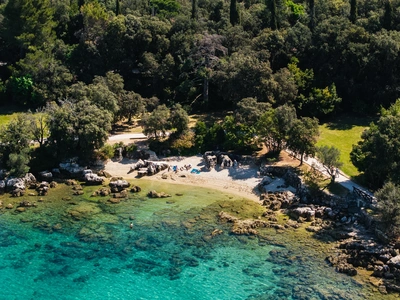 Small pebble cove shaded by oak trees