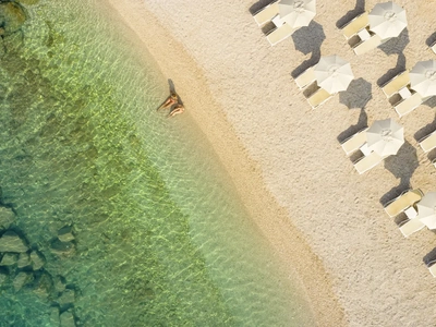 Plaža z ležalniki na otoku, posneta iz zraka. Foto: Maistra