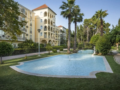 Zgodovinska hotelska stavba in bazen med mediteranskimi borovci. Foto: Maistra