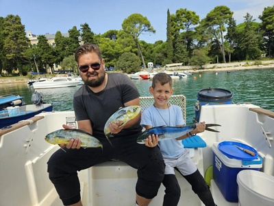 Family fishing trip off Rovinj — a father and son with fresh mahi-mahi — Rovinj